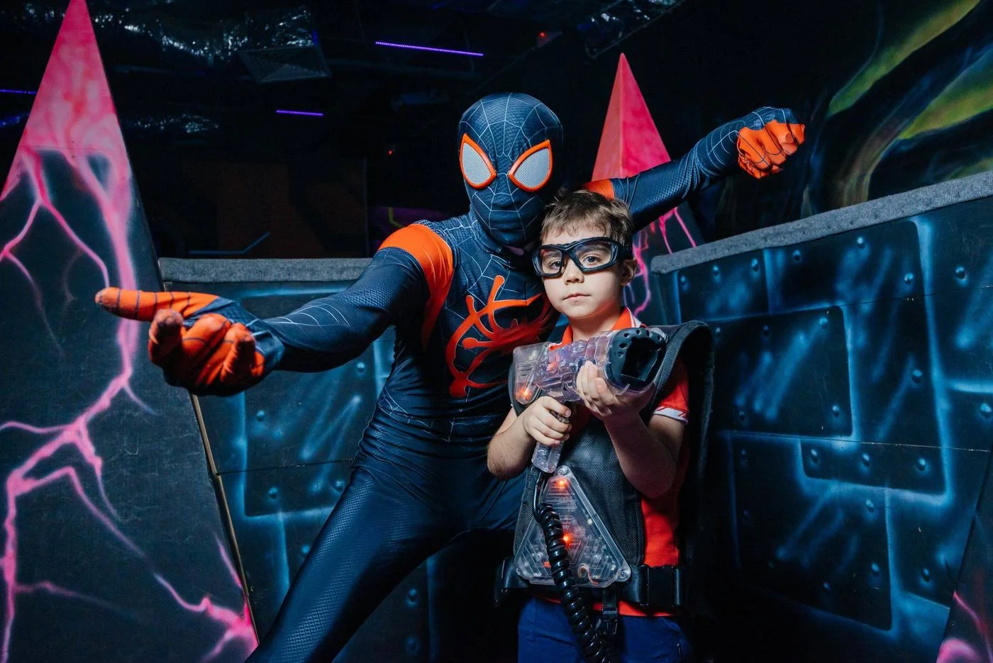 Аниматор и ребёнок с лазертаг-бластером на арене LaserLand Чита